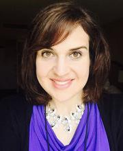 headshot photo of Lisa Litterio with medium length brown hair, a purple blouse and black jacket