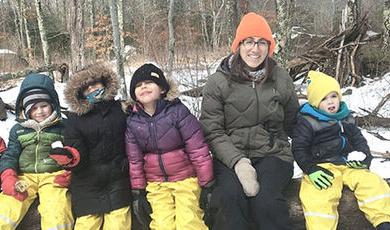 Cristy O'Brien with students sitting in the woods.