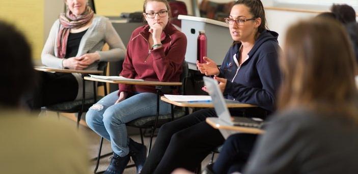 Professor and students sitting in a circle having discussion