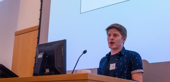 a BSU student stands at a podium giving a presentation